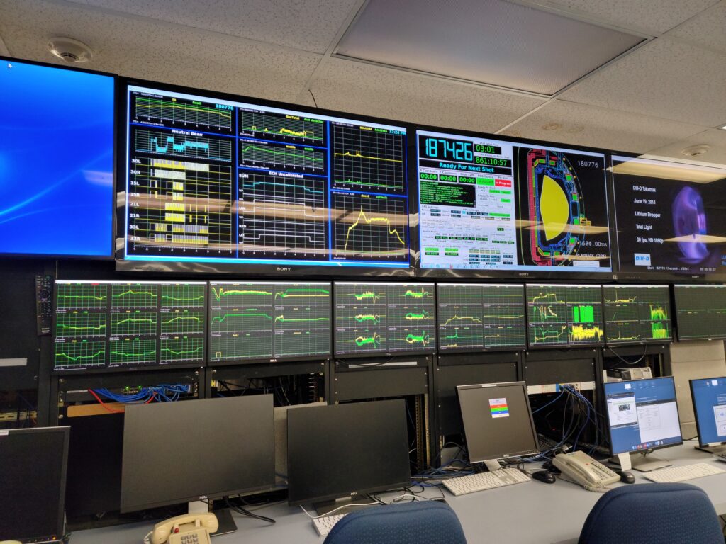 A bank of computer monitors displaying data from a plasma shot.