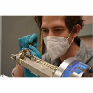 A scientist uses a screwdriver to align components of a diagnostic